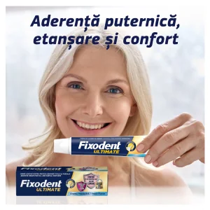 Femeie zambitoare tinand tub Fixodent Ultimate, cutia produsului este de asemenea vizibila in partea stanga jos. Femeie zambitoare tinand tub Fixodent Ultimate, cutia produsului este de asemenea vizibila in partea stanga jos.