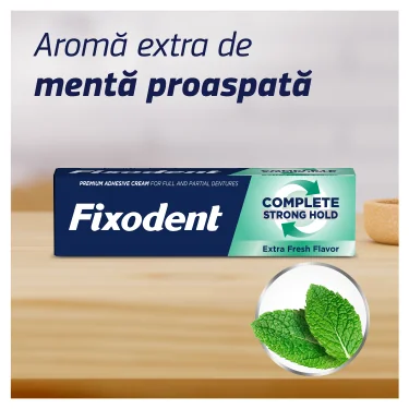 Cutie de Fixodent crema adeziva pentru proteza dentara, varianta Complete, aroma proaspata, langa frunze de menta. Cutie de Fixodent crema adeziva pentru proteza dentara, varianta Complete, aroma proaspata, langa frunze de menta.