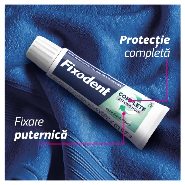 Tub de Fixodent Plus Food Barrier, crema adeziva pentru proteze dentare, cu fixare puternica si confort, pe un fundal albastru texturat. Tub de Fixodent Plus Food Barrier, crema adeziva pentru proteze dentare, cu fixare puternica si confort, pe un fundal albastru texturat.