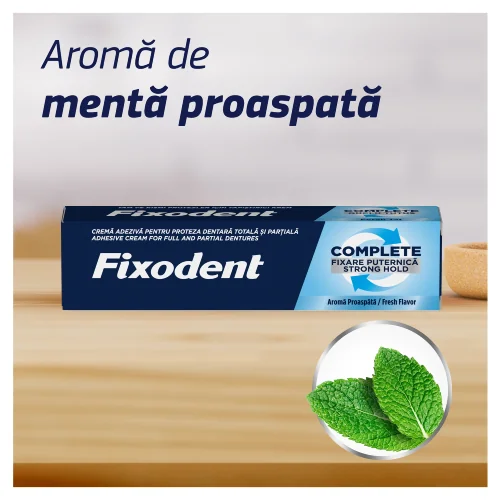 Cutie de Fixodent crema adeziva pentru proteza dentara, varianta Complete, aroma proaspata, langa frunze de menta. Cutie de Fixodent crema adeziva pentru proteza dentara, varianta Complete, aroma proaspata, langa frunze de menta.