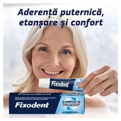 Femeie zambitoare prezentand Fixodent crema adeziva pentru proteze, cu cutia produsului vizibila in prim-plan. Femeie zambitoare prezentand Fixodent crema adeziva pentru proteze, cu cutia produsului vizibila in prim-plan.