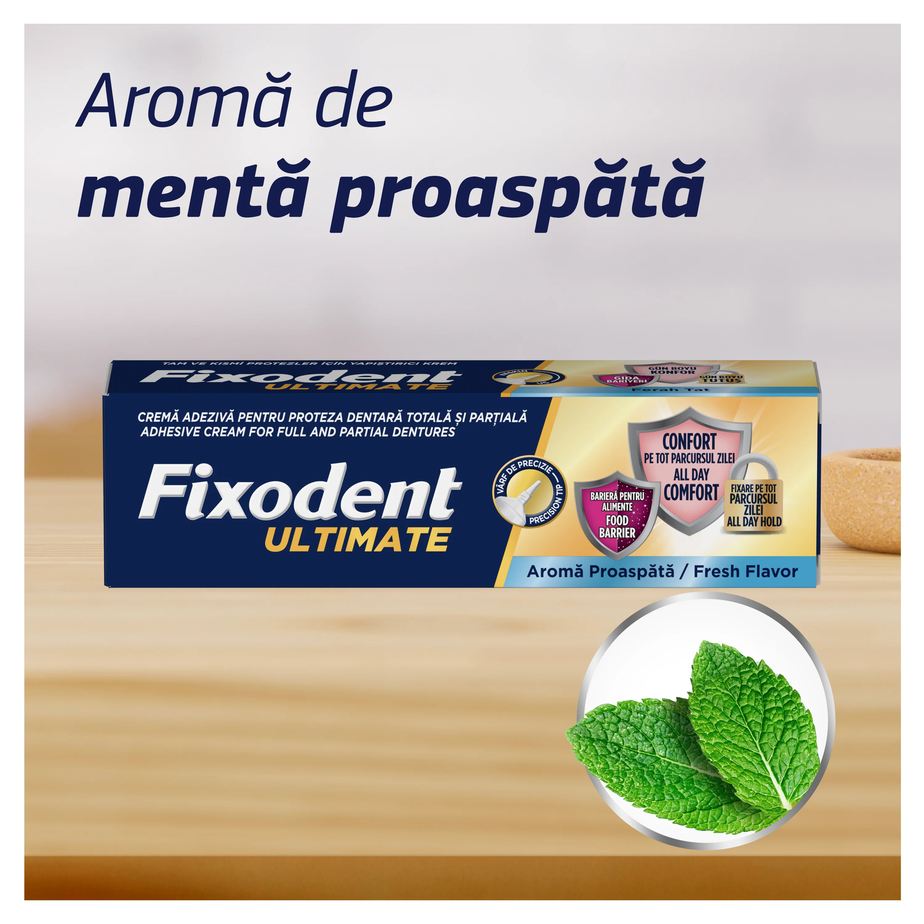 Cutie de Fixodent crema adeziva pentru proteza dentara, varianta Complete, aroma proaspata, langa frunze de menta. Cutie de Fixodent crema adeziva pentru proteza dentara, varianta Complete, aroma proaspata, langa frunze de menta.