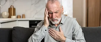 barbat in varsta care tine o mana la tampla si o mana pe piept barbat in varsta care tine o mana la tampla si o mana pe piept